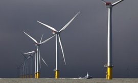 A boat passes between wind turbines at the London Array project, the world's largest windfarm