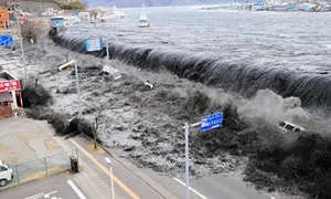 A tsunami breaches the flood barriers of Miyako city after north-east Japan is hit by an earthquake