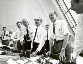 Happy Apollo 11 mission officials in the Launch Control Center following the successful Apollo 11 liftoff on July 16, 1969. Second from left (with binoculars) stands Dr. Wernher von Braun, Director of the Marshall Space Flight Center.